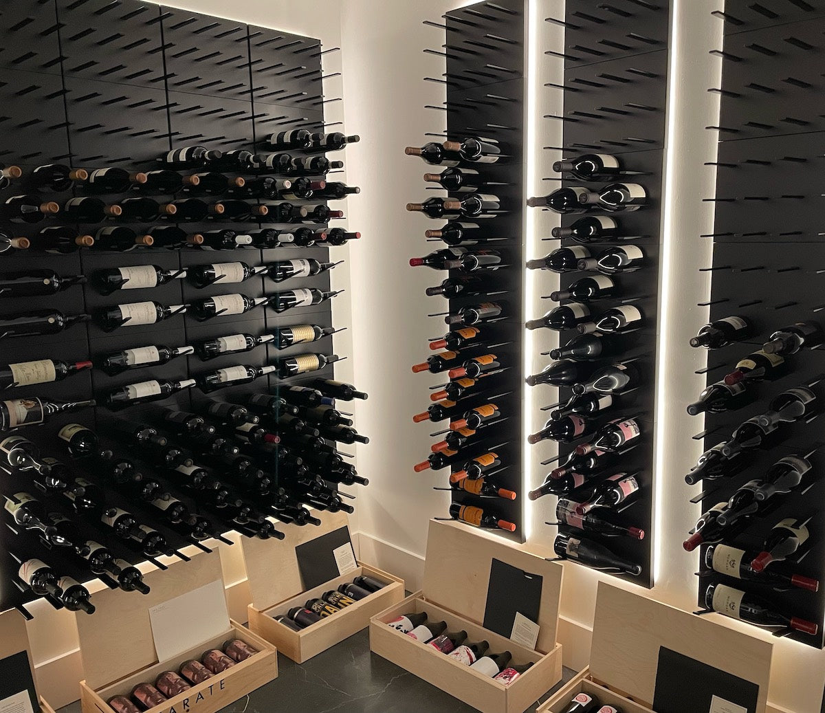 Backlit wine room using STACT Premier BlackOut label-forward and cork-out wall-mounted wine racks.