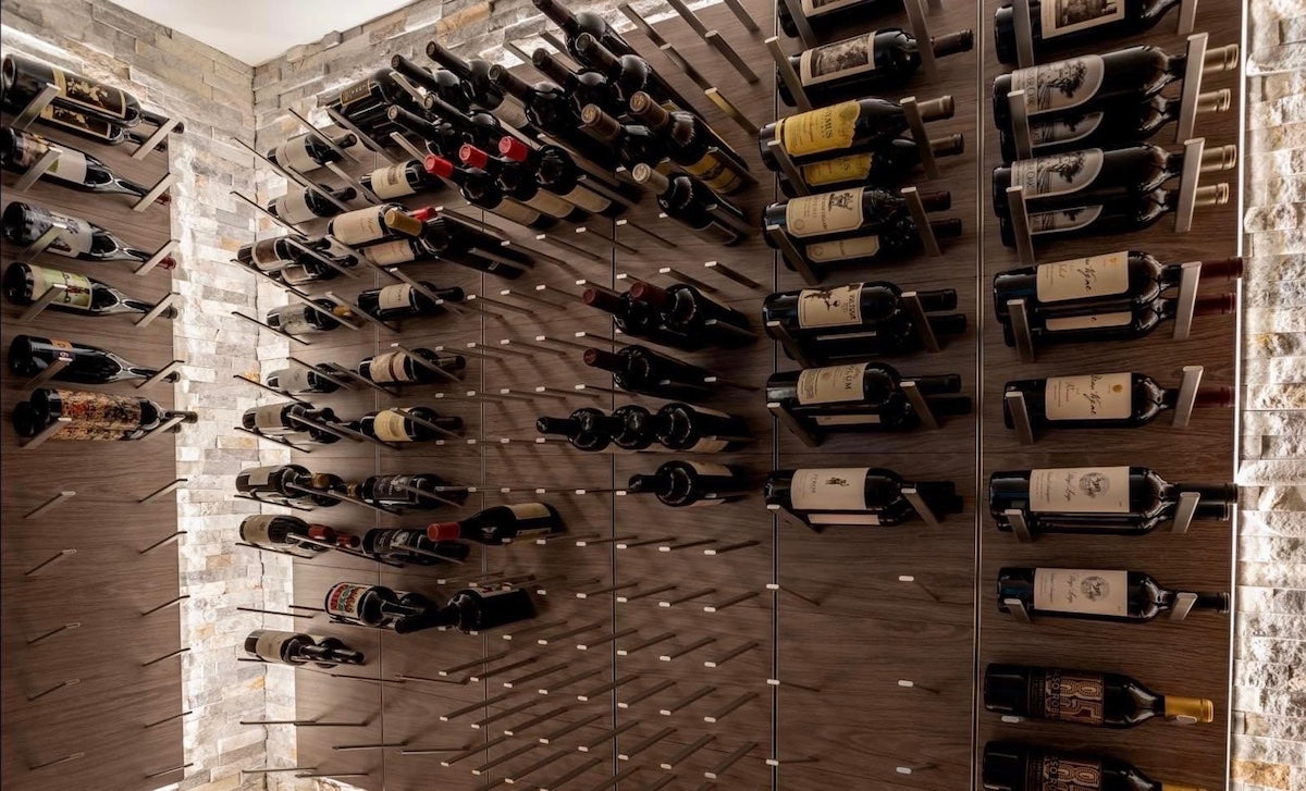 Contemporary wine room with LED backlit STACT Premier Gray Oak & Silver wine racks mounted on stacked stone.