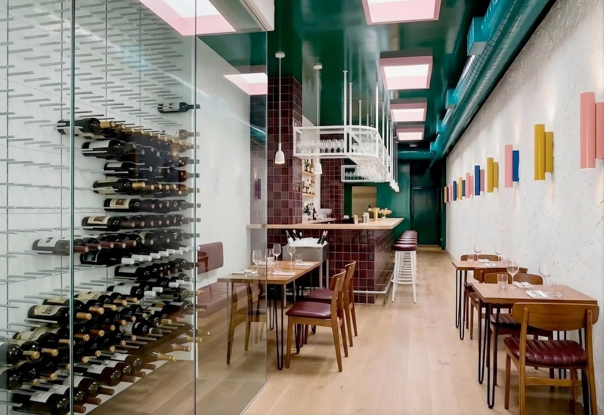 Modern restaurant with a glass wine wall featuring STACT Premier White & Silver wall-mounted wine racks.