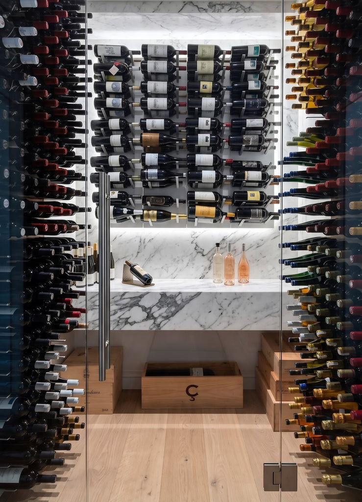 STACT Premier wine racks in Concrete & Silver inside a glass-fronted wine cellar with marble cabinetry.