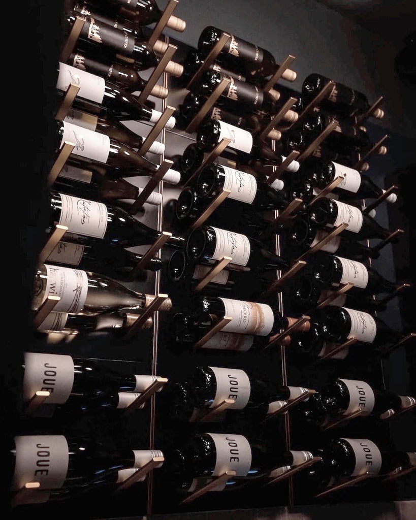 STACT Premier L-type wine rack in black and bronze with label-out bottle display on a contemporary feature wall