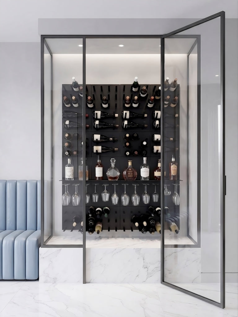 Glass-enclosed STACT Premier Shelf in BlackOut finish with bottles on display, hanging stemware below, black wine racks, and a white marble base.