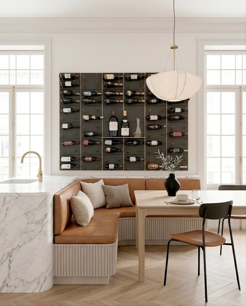 Modern kitchen with warm metal accents wine rack, bench seating, and dining table.